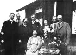 Kvinnan i mitten r Hedvig Sofia Larsson (fdd Alm) med barnen Sven, Henning, Gerda, Karl, Ingeborg, John och Gustav i bakgrunden frn vnster. Fotot r taget vid 