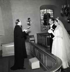 Brudpar med prst vid altaret under ett brllop i Knista kyrka - klicka fr att frstora