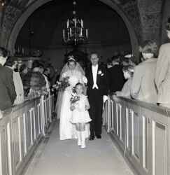 Brudpar med trna och flje vandrar ut lngs mittgngen under ett brllop i Knista kyrka - klicka fr att frstora