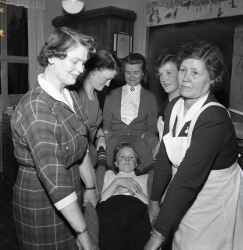En grupp kvinnor br en kvinna i en filt under en sjukvrdskurs fr Rda korset - klicka fr att frstora