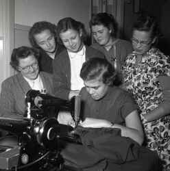 En grupp kvinnor kring en symaskin under en sykurs i Kvistbro. - klicka fr att frstora
