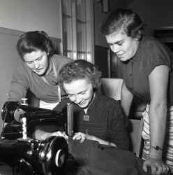 En grupp kvinnor kring en symaskin under en sykurs i Kvistbro. - klicka fr att frstora