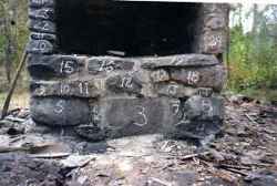 Härden i Bo bysmedja sedan väggar och tak flyttats till Högan med stenarna märkta. - klicka för att förstora