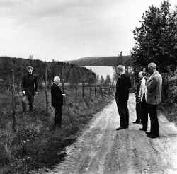 En grupp personer vid Tryggeboda med Multen i bakgrunden. Troligen r�r det sig om deltagare fr�n en rekogniseringsresa i Lekeberg i maj 1967. D� fick arkitekt Evald Nordin, ingenj�r Arthur Birkerot, regionplanechef Bo Fredzell, l�nsarkitekt G�ran Jonsson och distriktsarkitekt J�rg Budde se omr�det under ledning av redakt�r �ke Axelsson och kommunaln�mndens ordf�rande Erik Johansson. - klicka f�r att f�rstora