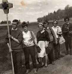En procession med sex personer på vallfärd till Riseberga anförd av en man med ett kors - klicka för att förstora