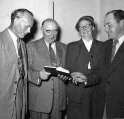 Fyra personer håller i en skrift under Bondeförbundets valmöte med statsrådet Skabersjö - klicka för att förstora