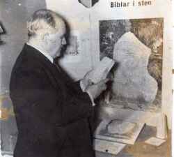 Komminister Eskil Hellman vid ett stenbibelbord på en av sina bibelutställningar - klicka för att förstora