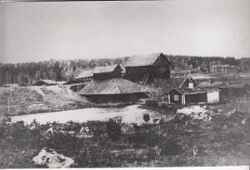 Vy över Klunkhyttan med rostugnshuset längst till vänster, följt av hyttan och masmästarstugan vid dammen - klicka för att förstora
