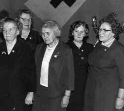 Damer vid syjunta med Röda korsets flagga i bakgrunden - klicka för att förstora