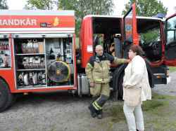 Brandmannen Per Åke Fransson berättar om sitt arbete för en kvinna - klicka för att förstora