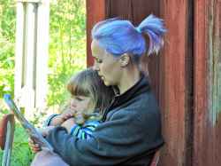 Karin Nilsson  med dottern Elna läser en saga  vid ett besök på Snarve den 9 augusti 2015 - klicka för att förstora