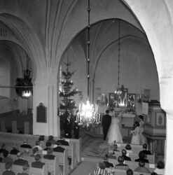 Tage och Ann-Marie Nilsson från Fjugesta inför prästen vid altaret under deras bröllop i Edsberg kyrka - klicka för att förstora