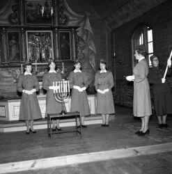 Sex kvinnor i uniform i koret i Kvistbro kyrka under invigning av lottor  - klicka för att förstora
