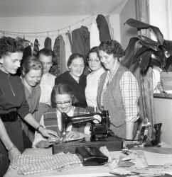 En grupp kvinnor kring en symaskin på systuga i Mullhyttan - klicka för att förstora