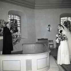 Brudpar med präst vid altaret under ett bröllop i Knista kyrka - klicka för att förstora