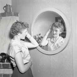 En kvinna speglar sig i samband med att fru Olsson i Ekhult fyller 75 år - klicka för att förstora