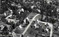 Flygfoto �ver Fjugesta. Fr�n v�nster till h�ger syns Hagagatan, Dammgatan och Parkgatan g� snett upp till h�ger. I �vre h�gra h�rnet skymtar j�rnv�gen. - klicka f�r att f�rstora
