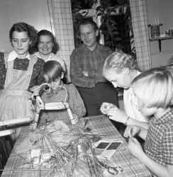 Tre kvinnor, tv� barn och en man g�r halmbockar hos Ola och Ingrid Nilsson med Kvistbro JUF - klicka f�r att f�rstora