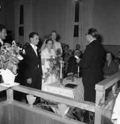 Petrus Skogholm och Elsa Gustavsson inför pastorn vid deras bröllop i Hidingebro pingstkapell  - klicka för att förstora