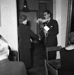 Sigurd Paulsson f�r blommor av en kvinna under Knista kyrkok�rs 20-�rsjubileum. - klicka f�r att f�rstora