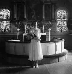 Flicka med blommor i koret i Kvistbro kyrka efter konfirmationen p�sken 1954 - klicka f�r att f�rstora