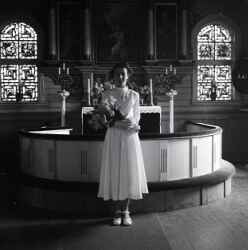 Flicka med blommor i koret i Kvistbro kyrka efter konfirmationen p�sken 1954 - klicka f�r att f�rstora