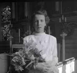 Flicka med blommor i koret i Kvistbro kyrka efter konfirmationen p�sken 1954 - klicka f�r att f�rstora