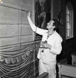 En man målar en vägg i samband med restaureringen av Kvistbro kyrka - klicka för att förstora
