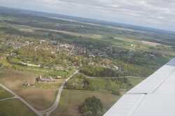 Flygfoto över Fjugesta mot öster med Edsbergs Sanna närmast kameran. - klicka för att förstora