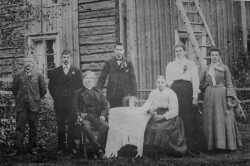 En bild fr�n Hinderstorp 1907. Vid bordet sitter makarna Lars-Peter Persson och Inga-Stina Olovsdotter. Bakom dem st�r fr�n v�nster sv�rsonen Herman Hel�n, parets s�ner Karl och Axel Larsson, dottern Josefina Hel�n och slutligen sonen Erik-Johans dotter Hilma Eriksson. - klicka f�r att f�rstora