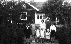 Familjen Eriksson i Staveläng sommaren 1930 med mamma Ebba och pappa Karl stående lite bakom. I främre raden från vänster står parets barn Stig, Dagny, Vivi och Stina,medan Karls bror Emils barn Nils-Olov och Tore syns längst till höger. - klicka för att förstora