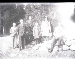 Tv kvinnor, tv pojkar och tre mn vid ett stenparti i ett skogsbryn - klicka fr att frstora