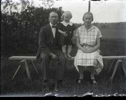 En man, ett barn och en kvinna p� en b�nk - klicka f�r att f�rstora