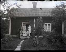 Fyra kvinnor och en man p� trappan till ett litet bostadshus - klicka f�r att f�rstora