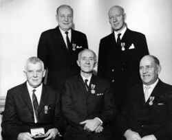 Fem kommunala förtroendemän har fått medalj. Sittande från vänster syns Erik Johansson, K G Andersson och Robert Linqvist medan Lennart Andersson och Johannes Granqvist står bakom - klicka för att förstora
