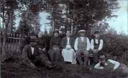 En grupp människor varav mejeristen i Binninge sitter med vit mössa på huvudet - klicka för att förstora