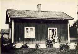 Byggnad med Klinga Kalle i dörren och Fritz och margit Andersson och Göte sittande framför - klicka för att förstora