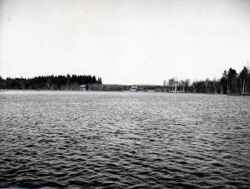 Bilden visar den uppståndna sjön med ladorna vid Åsunden utanför Bälsås i bakgrunden. Vattnet står även meterdjupt på Vena- och Edsbergsängarna och per båt kan man ta sig långt uppåt Torp i Tångeråsa. - klicka för att förstora
