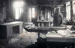 Interiör från Sandströms snickerifabrik med två män med möbler - klicka för att förstora